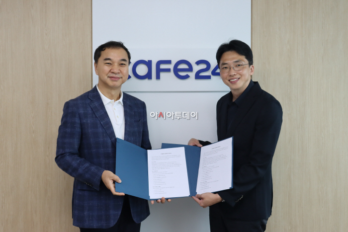 카페24 로고가 붙은 사무실 벽 앞에서 노수열 한국직업전문학교 대표와 김재은 카페24 비즈플랫폼팀 총괄팀장이 AI 인재 양성 산학협력 MOU 협약서를 펼쳐 들고 나란히 서 있다.